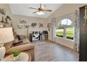Cozy living room featuring vaulted ceiling, wood-look floors, and bright arched window at 1020 N Orange Ave, Orange City, FL 32763