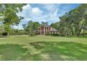 Lovely brick two-story home with a perfectly manicured lawn, mature trees, and meticulous landscaping at 1020 Orange Camp Rd, Deland, FL 32724