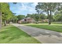 Two-story brick home on a large lot with an extended driveway and mature trees in a lush lawn at 1020 Orange Camp Rd, Deland, FL 32724