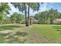 Two-story brick home with mature trees and a beautifully maintained front lawn, providing excellent curb appeal at 1020 Orange Camp Rd, Deland, FL 32724