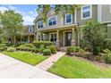 Beautiful townhouse with lush green lawn and landscaped garden leading to the front entrance at 10460 Burrows St, Orlando, FL 32832