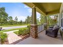 Inviting front porch with brick-based columns and cozy seating, perfect for relaxing outdoors at 10460 Burrows St, Orlando, FL 32832