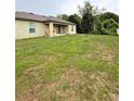Spacious backyard with a covered patio, lush lawn, and mature trees at 1115 Adirondack St, Deltona, FL 32725