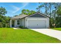 Well-maintained single-story home featuring an attached two-car garage and lush green lawn at 1161 Kenway Ave, Deltona, FL 32738