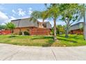 A condo with well-kept lawn, charming front patio, and a small balcony, framed by mature palm trees at 122 Cedar Dunes Dr, New Smyrna Beach, FL 32169