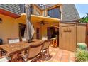 Private outdoor patio features a dining set, shade umbrella, and a Tiki bar, perfect for entertaining at 122 Cedar Dunes Dr, New Smyrna Beach, FL 32169
