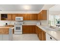 Bright kitchen featuring wooden cabinets, white appliances, ample counter space, and a well-lit, functional layout at 123 Wood Ibis Ct, Daytona Beach, FL 32119