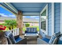 Cozy covered patio featuring comfortable seating, blue accents, and a peaceful outdoor view, perfect for relaxation at 123 Wood Ibis Ct, Daytona Beach, FL 32119