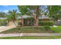 Inviting single-story home featuring a well-manicured front yard with mature trees at 1261 Burning Tree Ln, Winter Park, FL 32792
