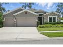 Charming home with a well-manicured lawn, stone accents, and a three-car garage at 1314 Lake Baton Dr, Deltona, FL 32725