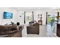 Comfortable living room with tile flooring, a cozy couch and well lit with natural light at 136 Columbia Dr, Kissimmee, FL 34759