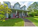 Charming home showcasing a welcoming front porch with elegant columns and a well-kept lawn at 1383 Tumblin Dr, New Smyrna Beach, FL 32168