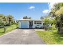 Charming light blue home featuring a single-car garage, well-kept lawn, and decorative nautical accents at 1420 N Grandview Ave, Daytona Beach, FL 32118