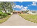 Charming single-story home with well-maintained lawn, long driveway, and a two-car garage at 1431 1St Ave, Deland, FL 32724