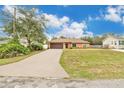 Charming single-story home with well-maintained lawn, long driveway, and a two-car garage at 1431 1St Ave, Deland, FL 32724