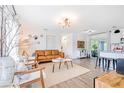Open-concept living area with stylish furnishings, wood-look floors, and an abundance of natural light at 1455 Whitewood Dr, Deltona, FL 32725