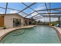 Enclosed pool featuring a screened enclosure, tile deck, and stairs leading into the clear blue water at 1660 E Apache Cir, Deltona, FL 32725