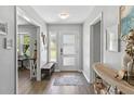 Bright foyer with modern door, bench seat, and wood-look flooring at 204 Rio Pinar Dr, Ormond Beach, FL 32174