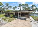 A screened-in porch with furniture overlooking a fenced backyard and a glimpse of the lake at 2620 Doyle Rd, Deltona, FL 32738