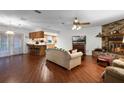 Inviting living room featuring a brick fireplace, wood floors, and an open layout into the kitchen at 270 Sandyhook Ln, Deland, FL 32724