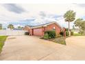 Spacious home exterior showing a large driveway, two car garage, and mature palm trees at 2724 N Halifax Ave, Daytona Beach, FL 32118