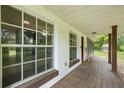 Spacious front porch with wooden floors, white trim and views of the surrounding greenery at 2950 Ragis Rd, Edgewater, FL 32132