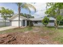 Charming single-story home featuring a metal roof, attached garage, and well-maintained front lawn at 3117 Pine Tree Dr, Edgewater, FL 32141