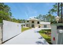 Two-story home featuring a circular driveway, lush lawn, and mature trees at 3428 Longleaf Rd, Ormond Beach, FL 32174