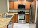 Well-equipped kitchen featuring stainless steel appliances, wood cabinets, and neutral countertops at 405 Carina Cir, Sanford, FL 32773