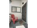 Exterior condo entrance with a red chair, doormat, and view of a window with a privacy shade at 4403 Sea Mist Dr # 2110, New Smyrna Beach, FL 32169