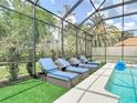 Beautifully screened-in pool featuring lounge chairs and outdoor seating and lush landscaping at 456 Sea Duck Dr, Daytona Beach, FL 32119
