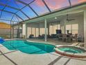 Screened-in pool with attached spa, covered patio, ceiling fans, and ample seating, perfect for relaxation at 456 Sea Duck Dr, Daytona Beach, FL 32119