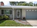 Inviting front entrance with stone walkway, a gray garage door, and colorful flower pots at 502 W Hogle Ave, Deland, FL 32720