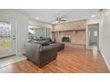 Cozy living room featuring a classic brick fireplace, hardwood floors, and ample natural light at 502 W Hogle Ave, Deland, FL 32720