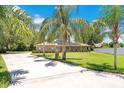Brick home with solar panels, lined with majestic palm trees, sits at the end of a private driveway at 519 Donaldson Dr, Debary, FL 32713