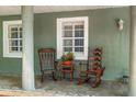 Welcoming front porch featuring rocking chairs and tiled flooring adding to the cozy, inviting atmosphere of the home at 552 Hamlet Dr, Port Orange, FL 32127