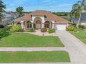 Charming one-story home featuring a well-manicured lawn and a welcoming facade at 6083 Sabal Hammock Cir, Port Orange, FL 32128