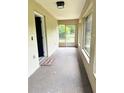 Enclosed front porch with concrete floor, light fixture, and screen door at 632 W Hubbard Ave, Deland, FL 32720
