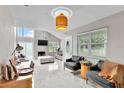 Open-concept living room with sleek tiled floors, contemporary lighting, fireplace, and comfortable seating at 64 Ravenwood Ct, Ormond Beach, FL 32174