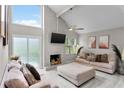 Bright living room features high ceilings, modern fireplace, and sliding glass doors to the outdoor area at 64 Ravenwood Ct, Ormond Beach, FL 32174
