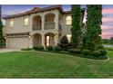 Two-story home with arched entry, manicured landscaping, and exterior lights at 762 Onyx Pkwy, Deland, FL 32724