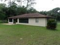 Spacious backyard featuring a concrete patio, lush lawn, and mature trees at 871 Oak Tree Ln, Lake Helen, FL 32744