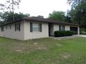 Classic single-story home with neutral stucco siding and dark trim around the windows at 871 Oak Tree Ln, Lake Helen, FL 32744