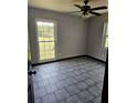 Neutral bedroom with tile floors, ceiling fan and large windows at 922 Saxon Blvd, Deltona, FL 32725