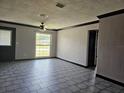 Inviting living room featuring tile floors, ceiling fan, and natural light at 922 Saxon Blvd, Deltona, FL 32725