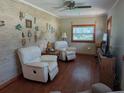 Cozy living room with wood paneling, two recliners, and a ceiling fan at 942 Lemon Bluff Rd, Osteen, FL 32764