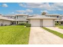 Well-maintained townhome exterior with a two-car garage and green lawn at 961 S Lakewood Ter # C, Port Orange, FL 32127