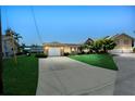Single-story home with manicured lawn, attached garage, and long driveway to the street at 10 Venetian Cir, Port Orange, FL 32127