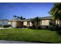 Well-maintained one story home with manicured lawn and mature landscaping under a blue sky at 10 Venetian Cir, Port Orange, FL 32127