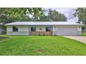 Inviting home exterior with a metal roof, manicured lawn, and lovely landscaping at 1017 Chippewa Trl, Daytona Beach, FL 32117